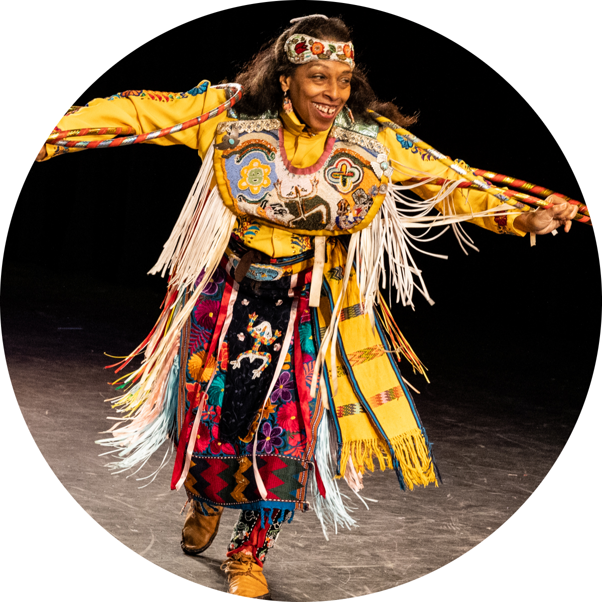 Native American dancer, Marie Ponce, performs at Symphony Space with arms outstretched to sides.