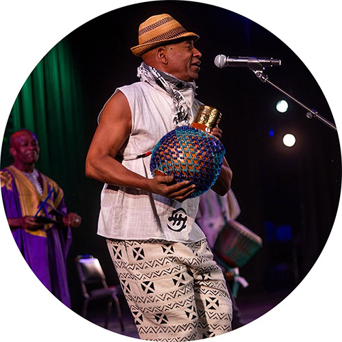 Performer onstage with a handheld drum.