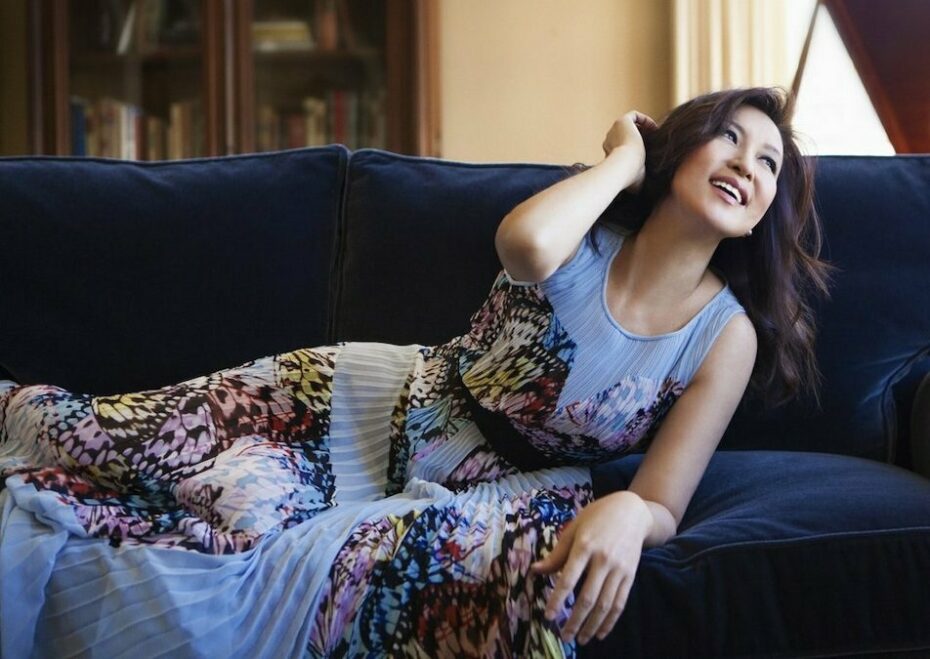 Pianist Min Kwon reclines on a navy blue couch.