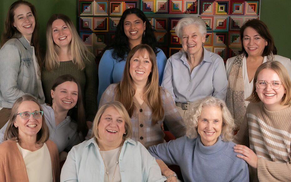 A group photo of performers from the choir. There are 11 women seated in the photo.