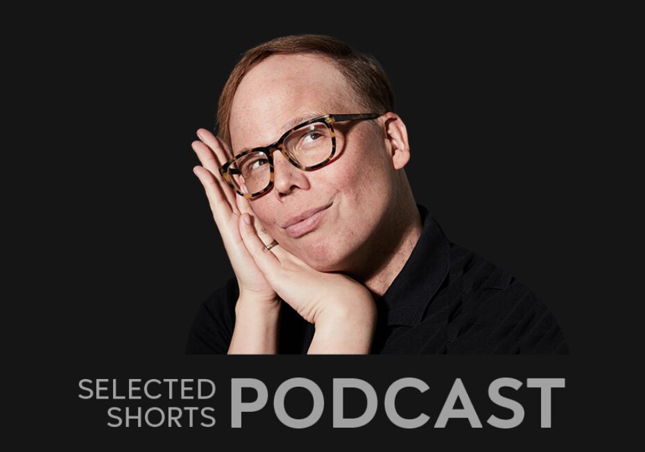 Jeff Hiller, a man, tilts his head to one side into his hands, while smiling.