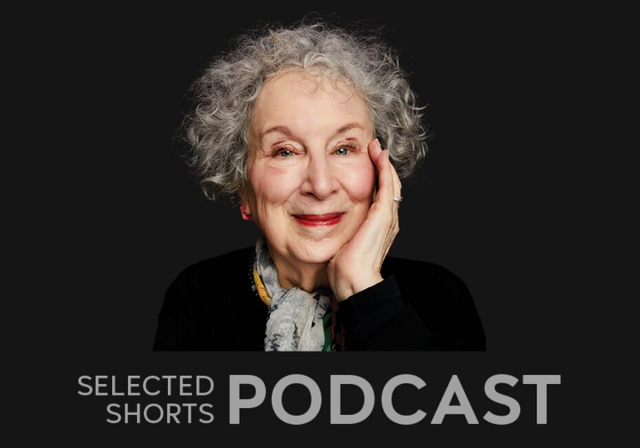 Margaret Atwood, a woman with gray curly hair, is smiling and holding her head in her hand.