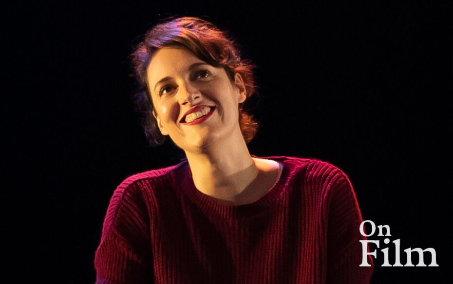Phoebe Waller-Bridge in Fleabag, wearing a red sweater and lipstick. She is smiling.