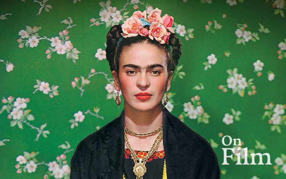 Frida Kahlo in front of a green floral background.