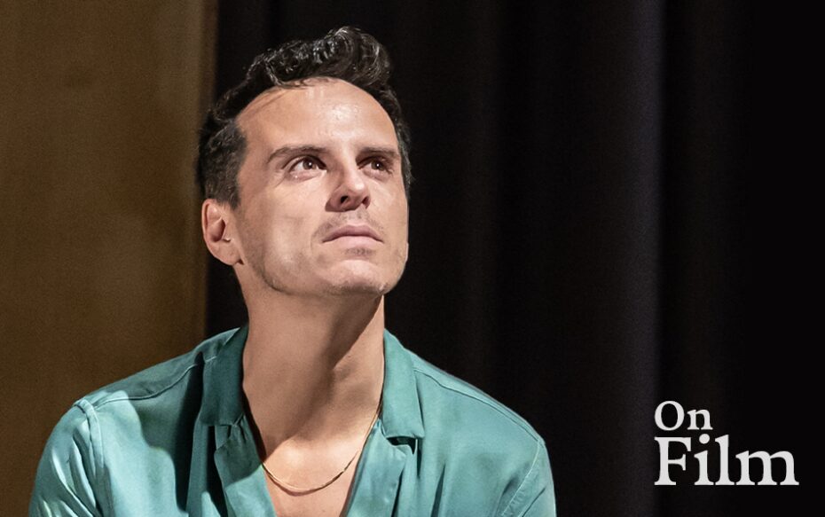 Actor Andrew Scott performing in Vanya. He is wearing a blue shirt and a gold necklace.