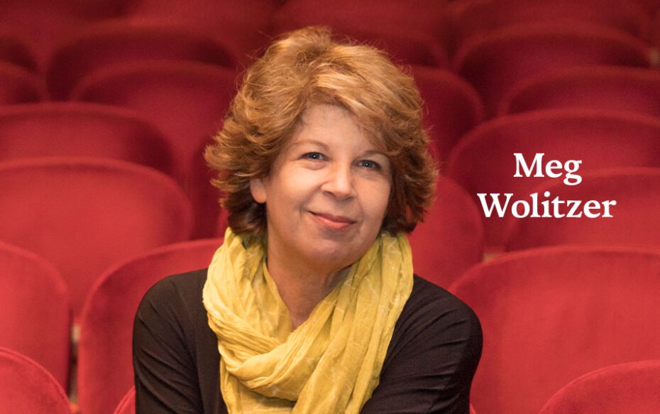 A headshot of author Meg Wolitzer, seated in a theater of red-upholstered seats. The author's name appears in white text on the right side of the image.