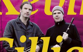 Kevin Crawford and Cillian Vallely holding their instruments in front of a pink background, with text that says, "Kevin and Cillian."