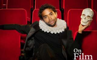 Hiran Abeysekera in costume as Hamlet, holding a skull.