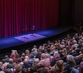 An audience faces a stage.