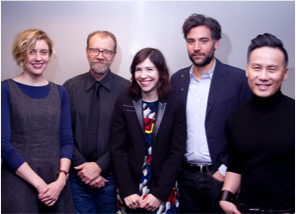 Five actors stand in front of a white wall smiling.